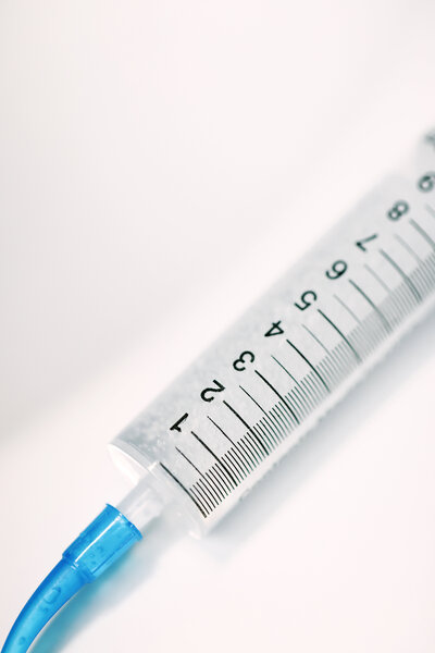 A close-up image of an injectable tooth-shaped device designed to dispense teeth whitening gel. The device resembles a tooth in shape and is filled with whitening gel, ready to be applied to the teeth. The gel is dispensed from a small opening at the tip, allowing for targeted and precise application. The tool is compact, ergonomic, and intended for professional or at-home teeth whitening treatments.