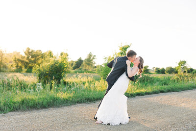 bride and groom kissing during sunset on wedding day