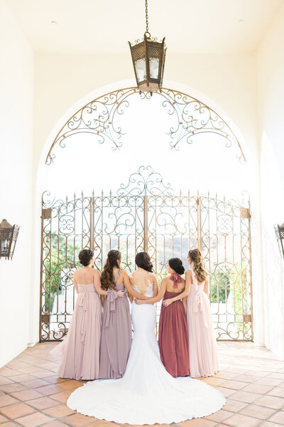 Bridesmaids embrace their bride on her wedding day