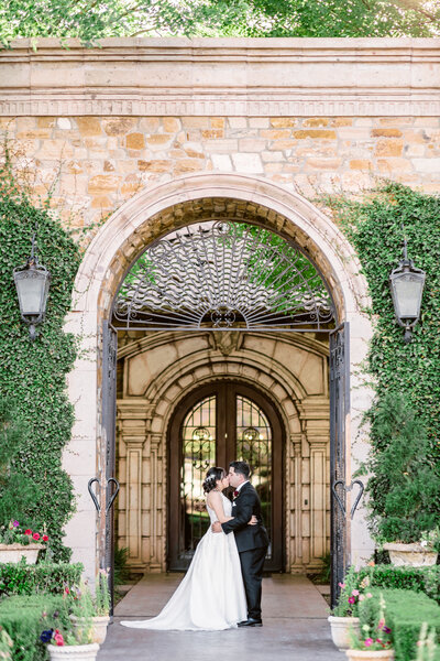 Bridal party celebrating a kissing bride and groom