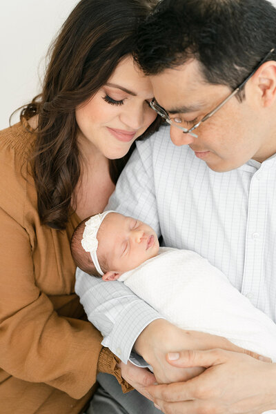 New parents hold their sleeping baby boy in this bright, light natural newborn photo shoot at Julie Brock Photography in Louisville KY