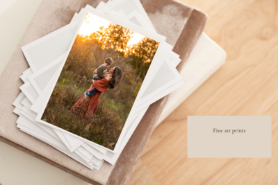 A stack of photography prints of a mom holding her son