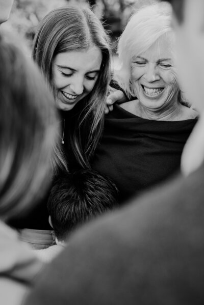 Black and white extended family photo with nephew hugging aunt and grandmother