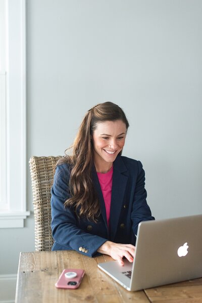 Richmond, VA wedding photographer working at her laptop, editing beautiful wedding photos and providing personalized photography services to couples
