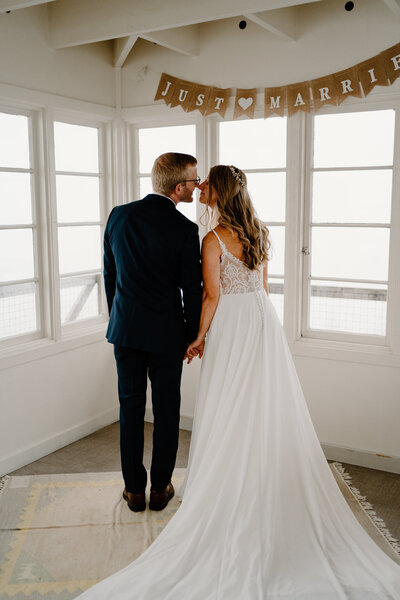 A couple in wedding attire kiss in a remodeled fire lookout in washington