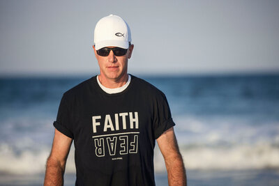 Mark Sullivan on the beach wearing a faith over fear shirt – Life and Health Coach at LifeNBalance Coaching1