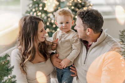 Adorable family photography by Cassey Golden of a young boy and girl hugging and making adorable faces while being held by mom and dad.