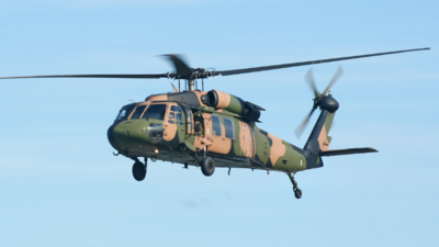 A camouflaged military helicopter in flight, representing dedicated nutrition support for DVA veterans and war widows.