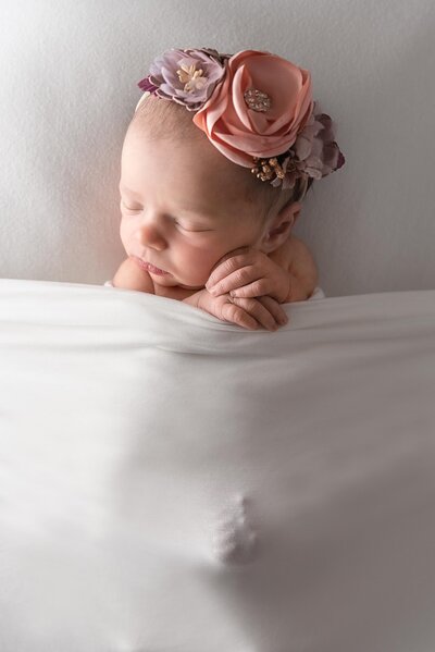 baby tucked in with flower headband