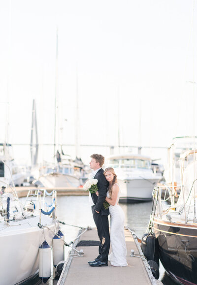 bride and groom standing on boat dock