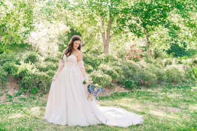 A smiling brunette bride in Duke Gardens enjoying her Raleigh wedding photography bridal portrait session by JoLynn Photography