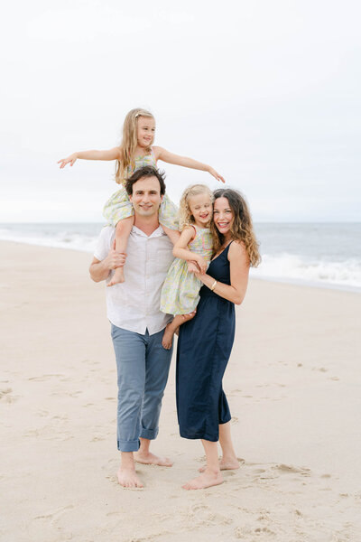 Cute family with three boys plays in a field during the fall