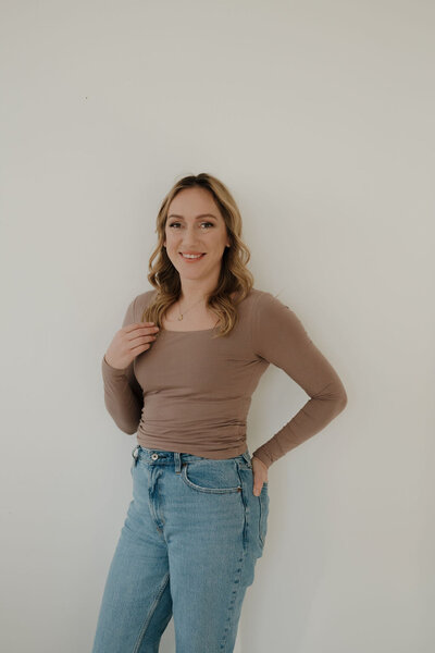 event planner milwaukee wi for Dream Weddings, Molly, smiles at the camera with one hand in her back jeans pocket and the other holding her hair.