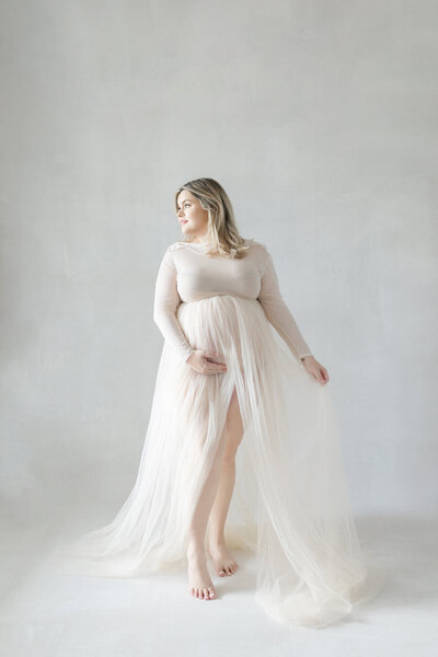 Elegant Tampa maternity portrait of mom-to-be in flowing gown and natural window light