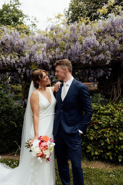 Bruidspaar poseert voor Blauweregen tijdens trouwfotoshoot 