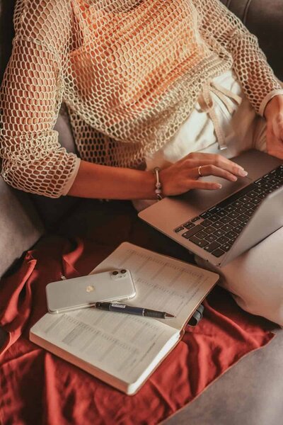 close up photo of woman sitting with laptop and an open book