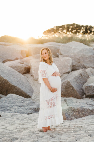 Pregnant mom on beach holding baby bump