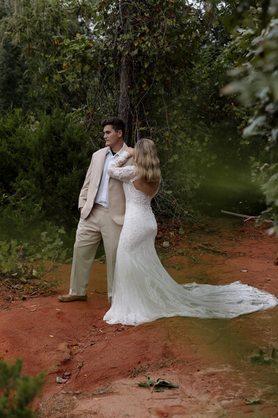 A luxurious green environment surrounds the eloping couple as the bride leans into the groom's shoulder, taking in their adventure wedding experience. 