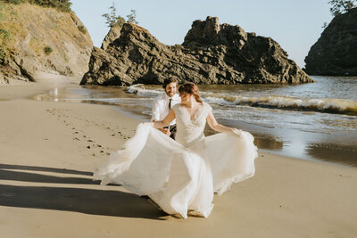 couple running on the beach after elopement