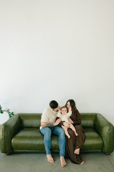 A couple bride and groom embraces in a kiss to the head during their wedding day