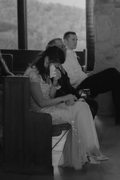 Black and white shot of the mother of the bride crying as she holder her husbands hand, Intimate Wedding Photography NYC and Asheville Area