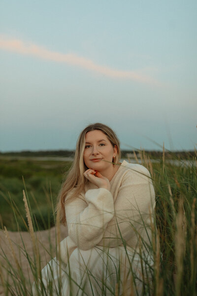 megan shaw posing next to beach grass in pei