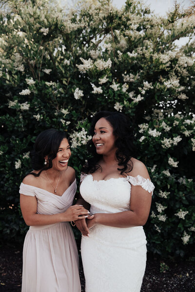 Bride with bridesmaid having fun and laughing
