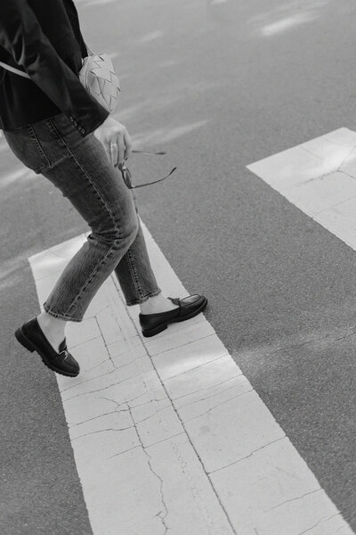 Black and white image of copywriter Anna Bradshaw walking across a crosswalk