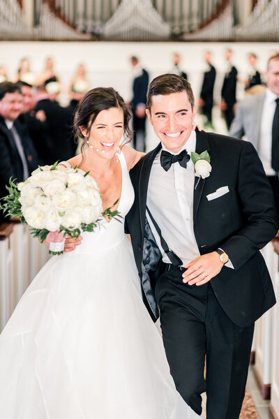 bride and groom running with big smiles running up the aisle after being married at Reid Chapel in Birmingham taken by Birmingham Alabama Wedding Photographer Emily McIntyre Photography
