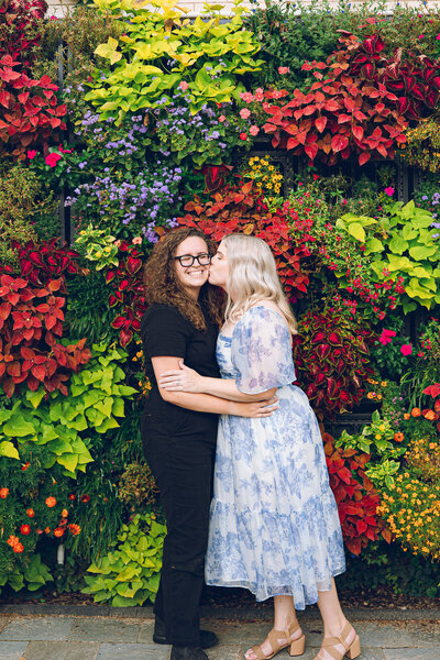 A queer couple share a kiss after their proposal at Garfield Park Conservatory