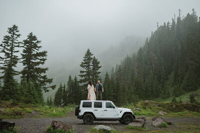 mount baker elopement couple stand top of jeep