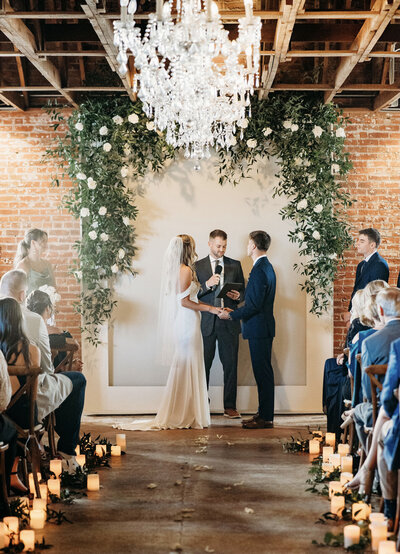 Wedding ceremony at the St Vrain with candles, greenery and chandeliers