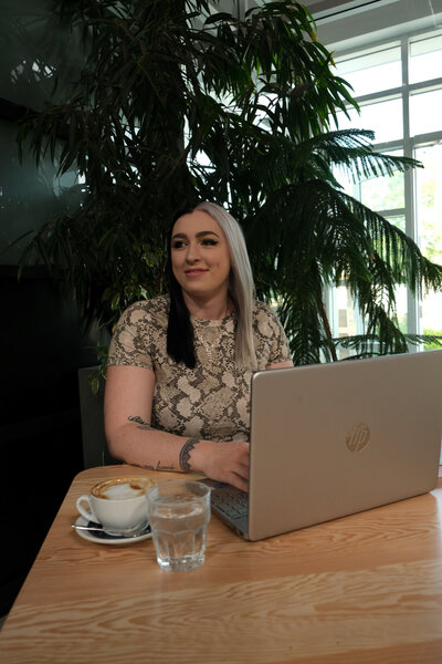 Dani poses by laptop working on Writing solutions for unique brands