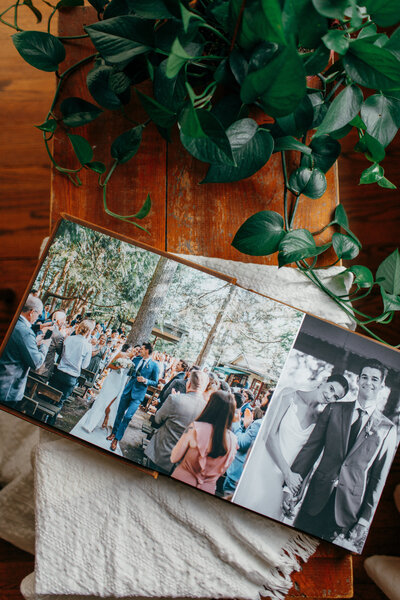 a fine art leather wedding album laying flat open with pictures of a wedding couple inside
