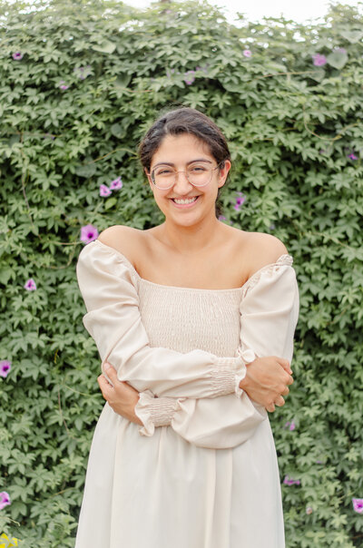 amsterdam photographer smiles in front of a wall of purple morning glories