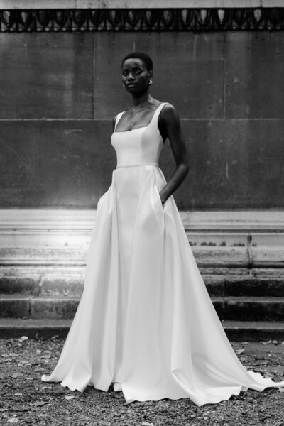 black and white image bride wearing scoop neck satin wedding dress with pockets