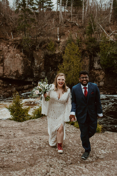 bride and groom walking through field