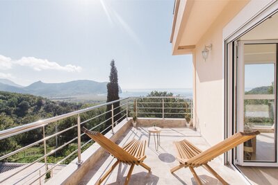 Balcony with two chairs and sea and mountain view