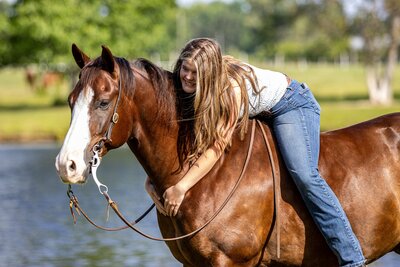 A girl sitting on her horse and hugging it during a portrait session in Smithfield, North Carolina.