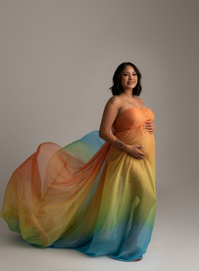 Rainbow-colored flowing maternity fabric titled "Rainbow Baby"