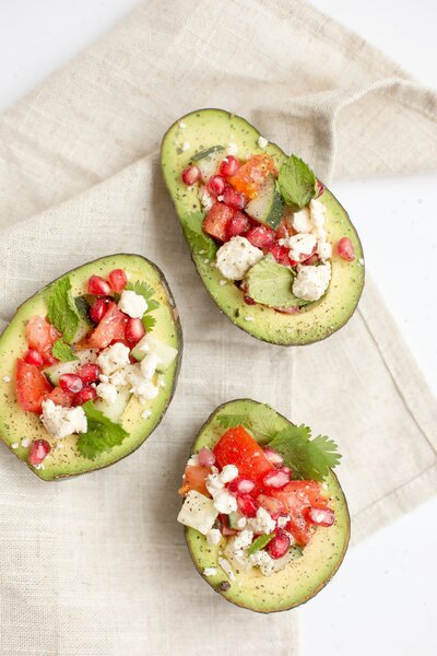 a healthy nutritious snack of avocado, tomatoes, cilantro and feta cheese 