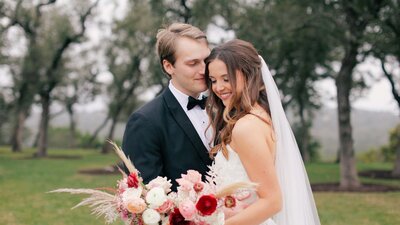 Bride and groom together with bouquet of pink flowers