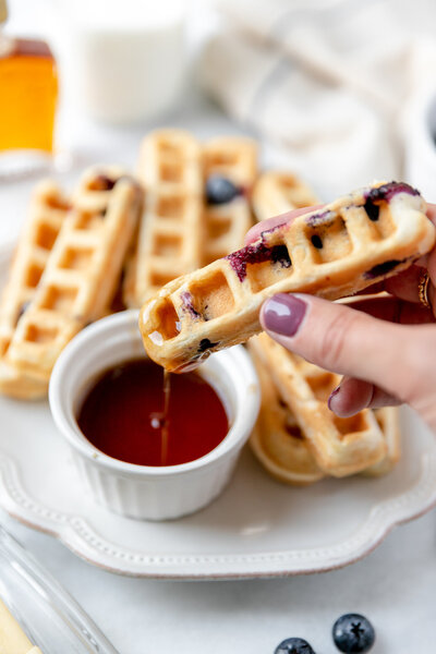 a waffle stick that has been dipped in syrup