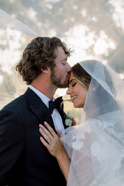 wedding-couple-intimate-kiss-under-veil-romantic-moment