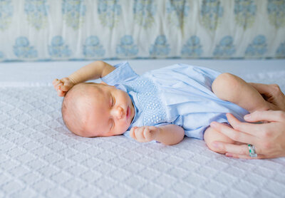A newborn baby lying across the bed during in-home newborn session with Allison Krogness Photography.