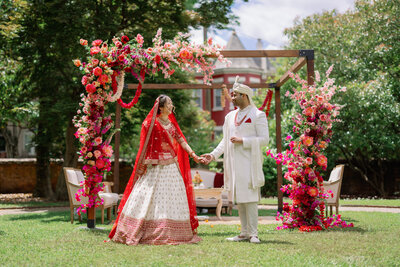 couple holding hands in front of mandap from their Indian wedding ceremony at the Branch Museum