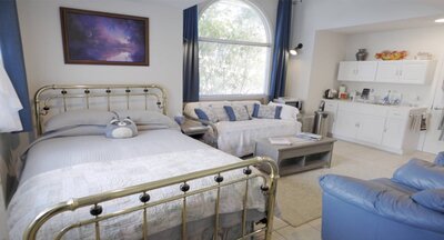 Bedroom with white bedding and couch