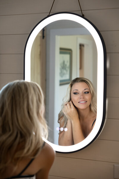 Bridal portrait at The Venue at Valley View Farm in Jackson SC - Bride smiling at her reflection in an arched mirror during her wedding season.