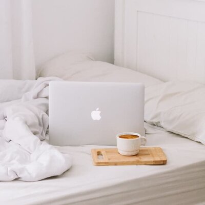 Laptop on bed showing course creation design process, step 3: creation and design