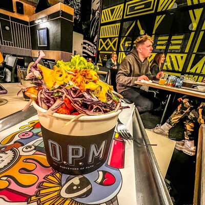 Tub of loaded fries with the letters OPM written on it